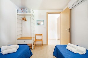 A bedroom with two beds, a wardrobe, a chair, and an air conditioning unit. - Sicilian Oasis, 200 meters from the Sea (Ognina)