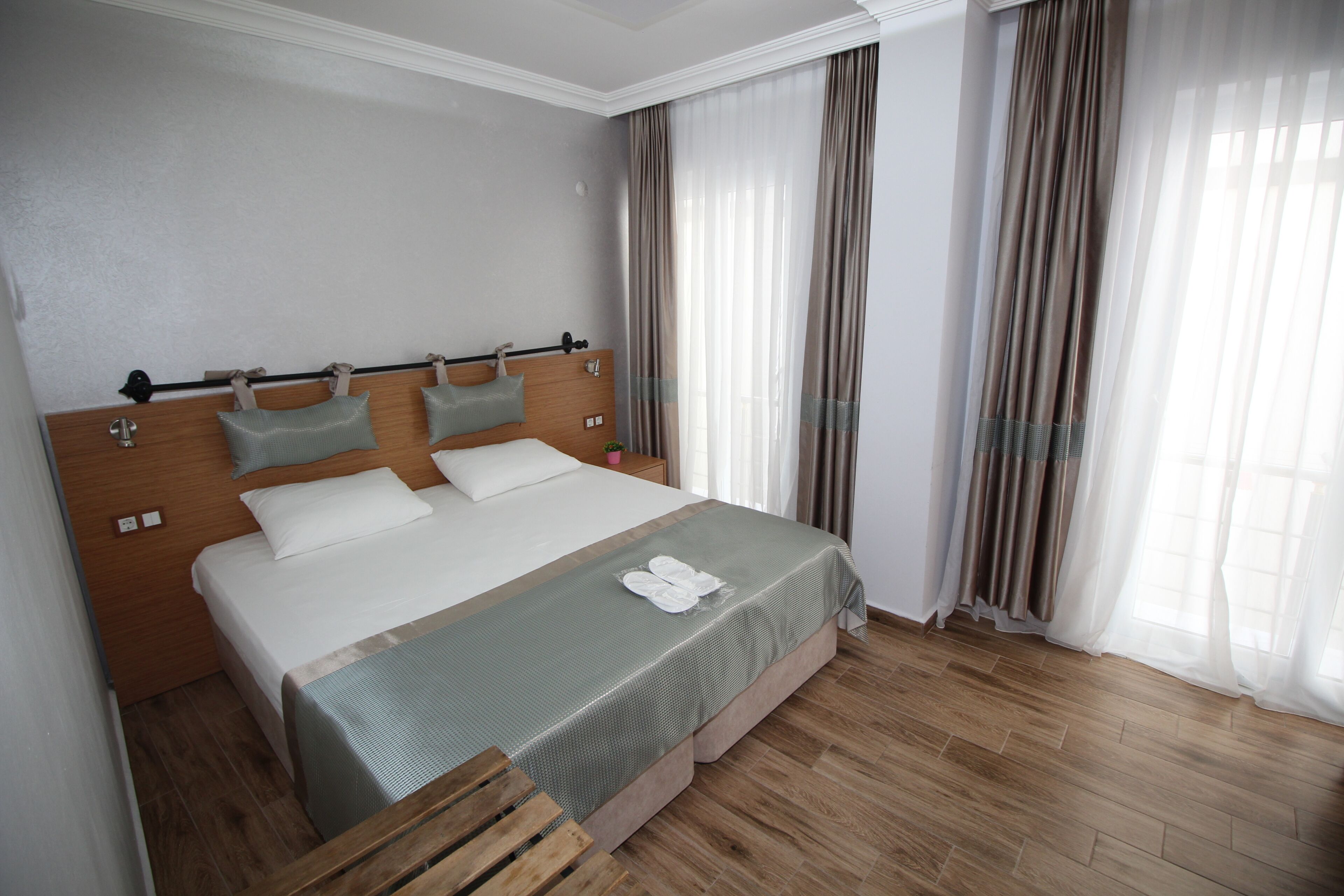 Une chambre d’hôtel bien aménagée, avec un grand lit, une tête de lit en bois et un banc en bois.