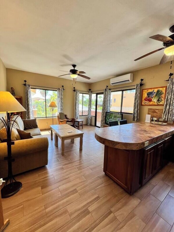 A spacious living area with a sofa, coffee table, and a kitchen island. - Heart of Los Barriles Short Walk to Beach (Los Barriles)