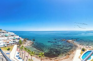 Ein Küstenhotel mit Pool, Strand und klarem, blauem Meer.