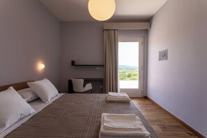 A hotel room with a bed, a desk, a chair, a window with curtains, and a view of the outdoors. - Agriturismo Fontanavecchia (Torrecuso)
