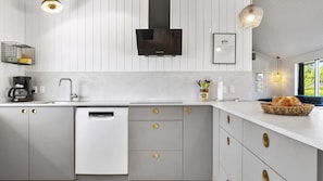 A modern kitchen with a dishwasher, a coffee maker, and a bread basket on the counter. - VillaVilla 980 - Juelsminde, Østjylland (Juelsminde)