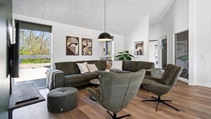 A modern living room with a sofa, armchairs, a coffee table, and artwork on the walls. - VillaVilla 962 - Marielyst, Lolland/Falster/møn (Idestrup)