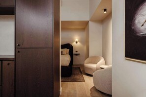 Ein Schlafzimmer mit Bett, Stuhl, Nachttisch und einer Wandlampe.
