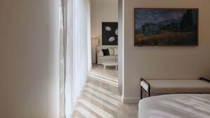 Une chambre d’hôtel avec un lit, un tableau, un canapé et une table basse.