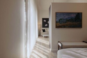 Ein Hotelzimmer mit Bett, Gemälde, Sofa und Couchtisch.