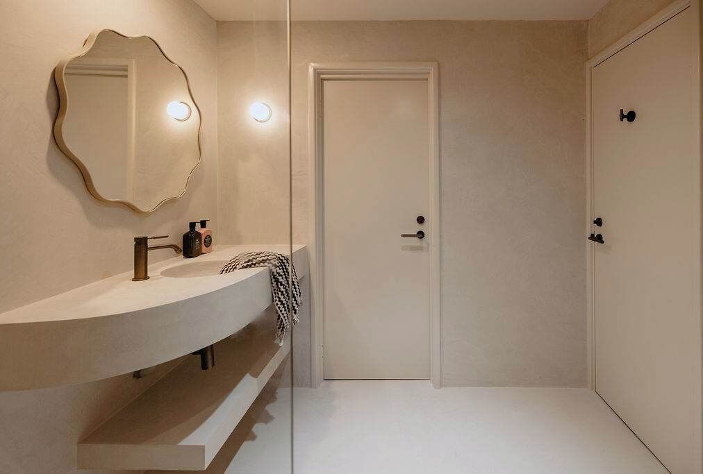 Clean architectural lines and soft natural light throughout the bathroom.