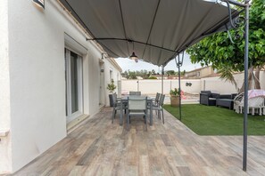 A patio with a table and chairs, a covered area, and a lawn. - Quiet villa with a heated pool and gym on the Côte Bleue and in Marseille (Châteauneuf-les-Martigues)