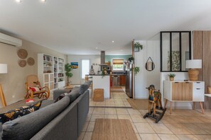 A modern living room with a sofa, a dining table, and a kitchen area. - Quiet villa with a heated pool and gym on the Côte Bleue and in Marseille (Châteauneuf-les-Martigues)