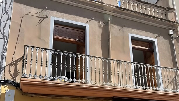 A building with two windows and a balcony with ornate metal railings. - La Divina: Apartment with Balcony in the Heart of Figueres (Figueres)