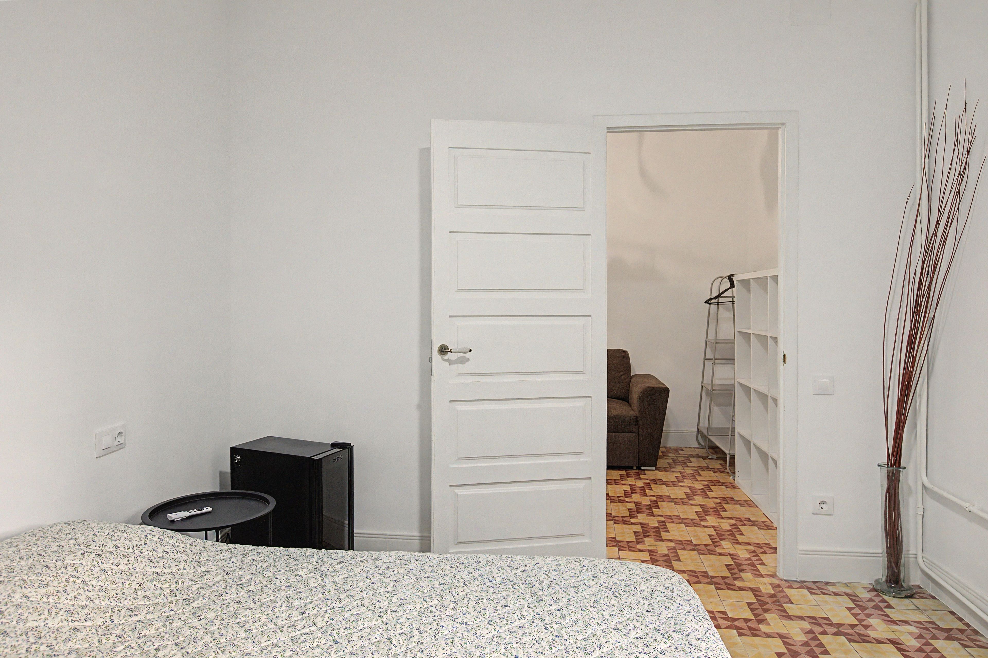 Ein Schlafzimmer mit Bett, Schreibtisch, Stuhl und Kleiderschrank.