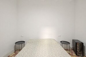 Une chambre avec un lit, deux tables de chevet et un téléviseur.