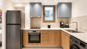 Una cocina moderna con horno empotrado, cafetera y lavavajillas.