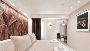 Una habitación de hotel con una cama grande, un comedor y una decoración moderna.