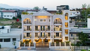 Un hotel de varios pisos con balcones, una entrada principal y vistas del barrio circundante.