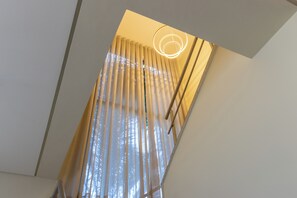 A room with a modern ceiling design, a visible window with curtains, and a light fixture. - Casa Serena | Oceanfront, Heated Pool, Jacuzzi & Fireplace (Florianópolis)
