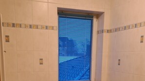 A bathroom with a window, a toilet, a sink, and a bathtub.