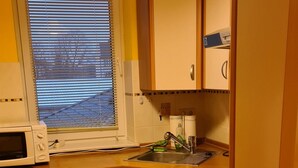 A compact kitchen with a microwave, sink, and oven.