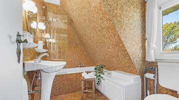 Een badkamer met een wand met honingraatmotief, een witte wastafel, een douche en een toilet.