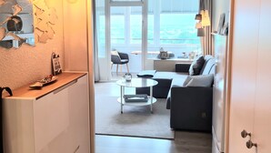 Un soggiorno moderno con divano, tavolino da caffè e vista sull'esterno.