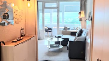 Uma sala de estar moderna com sofá, mesa de centro e vista para o exterior.