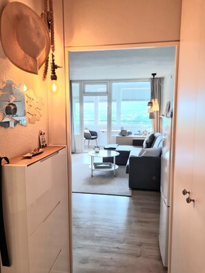 Ein modernes Wohnzimmer mit einer Couch, einem Couchtisch und Blick ins Freie.