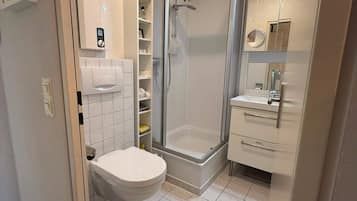 A modern bathroom with a shower, toilet, and vanity.