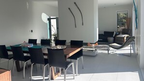 Een moderne eetruimte met een houten tafel, zwarte stoelen en een decoratief middelpunt.