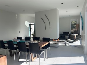 Un espace repas moderne avec une table en bois, des chaises noires et une pièce décorative centrale.