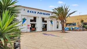 Ein Gebäude mit der Aufschrift 'Oasis Papagayo' und einem gefliesten Eingangsbereich.