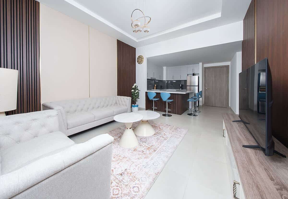 Un salon moderne avec un canapé, une table basse et un téléviseur.