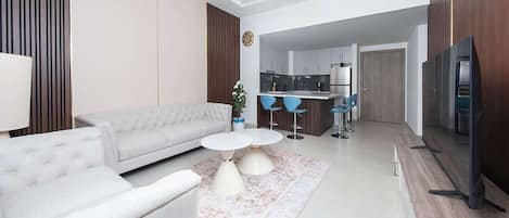 A modern living room with a sofa, coffee table, and a TV.