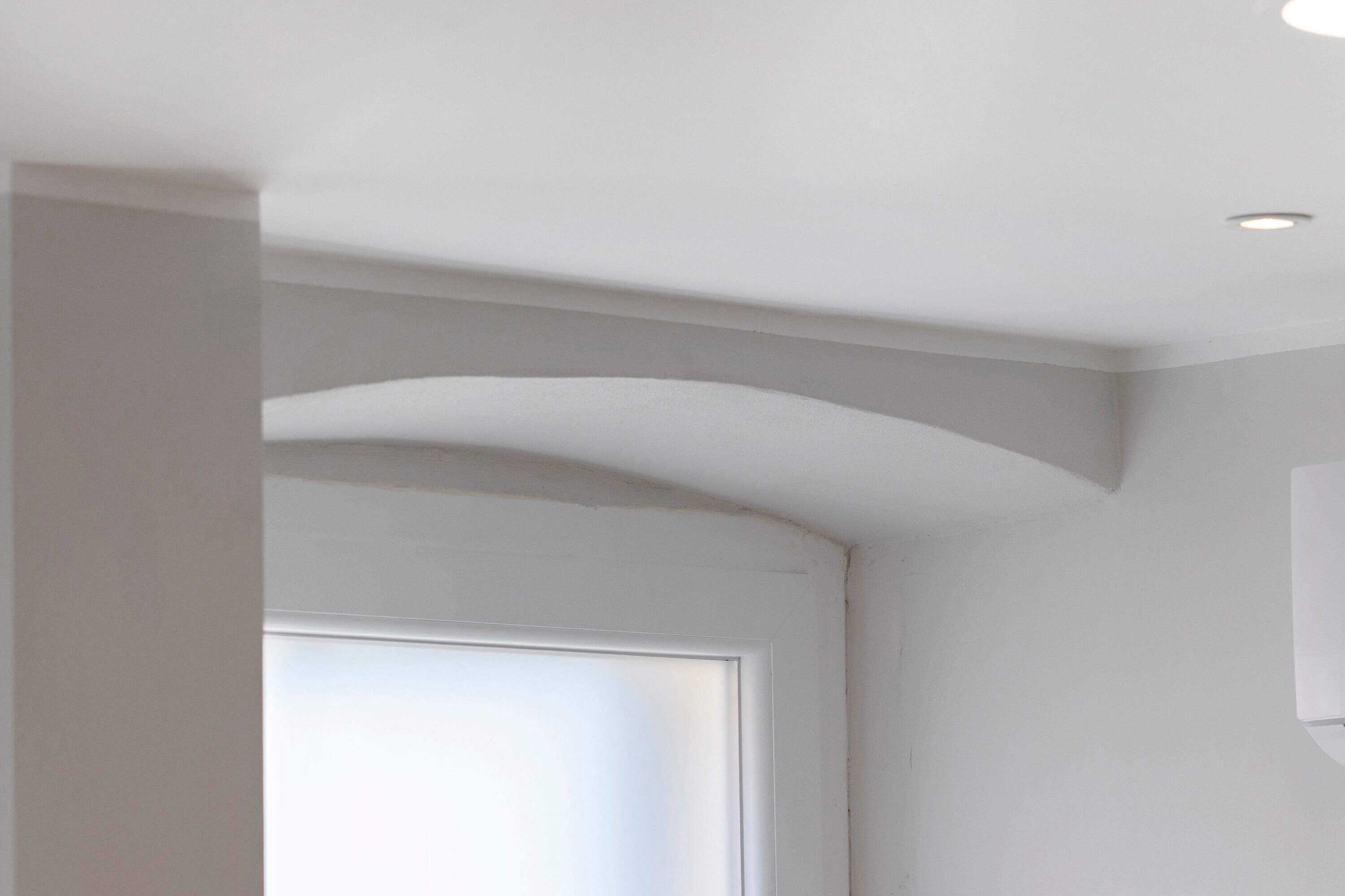 Une pièce avec une porte blanche, un plafond blanc et un mur blanc.