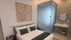 Ein Schlafzimmer mit einem Bett, Nachttischen, einem Kleiderschrank, einem Spiegel und einem gemusterten Teppich.