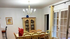 A dining room with a table, chairs, a chandelier, a cabinet, and a door with glass panels. - Villa with a private pool (Fayence)