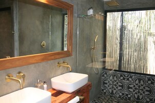 Un baño con dos lavamanos, un espejo grande y una ducha.