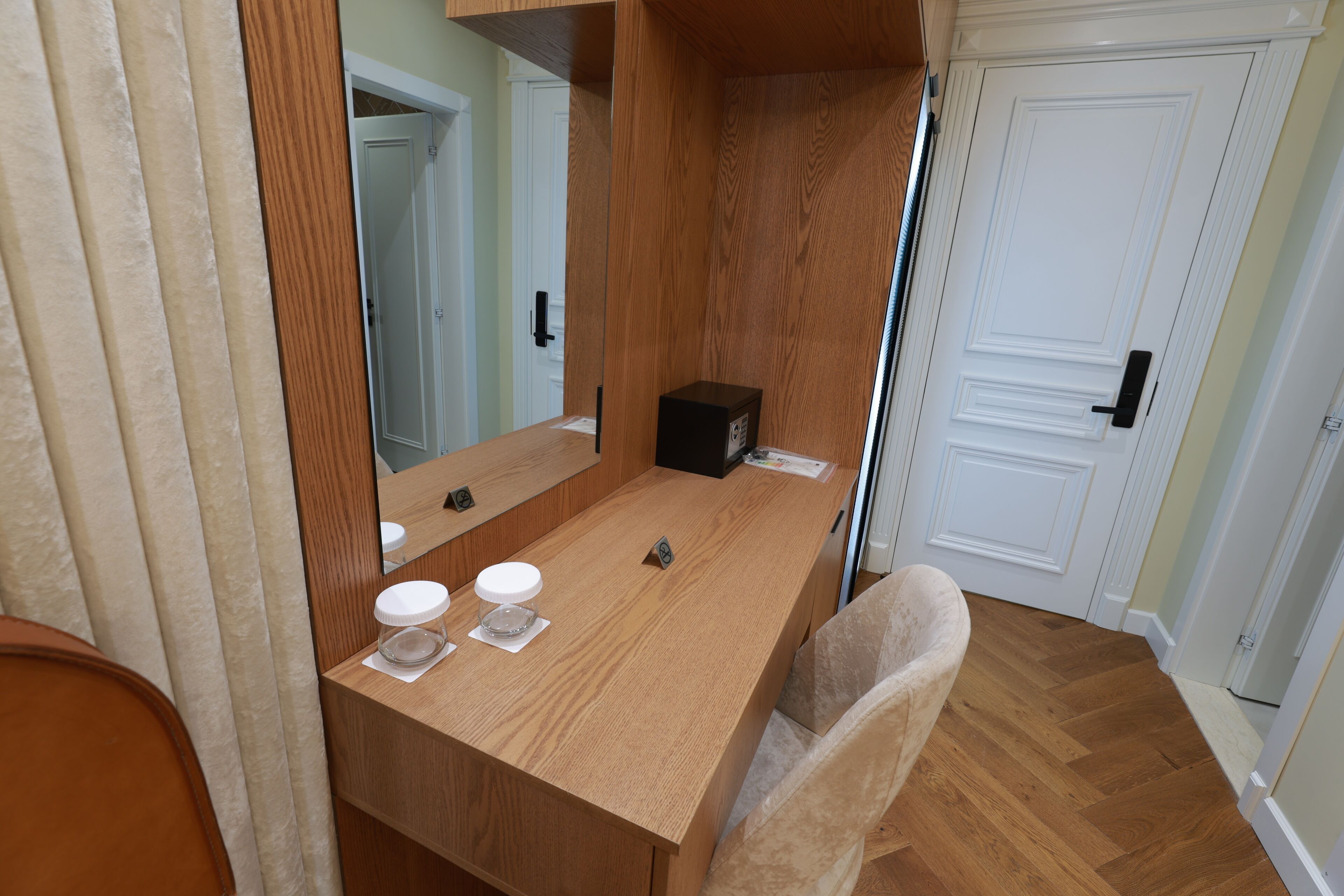 Ein Badezimmer mit einem Holzkonsolenunterschrank, einem Spiegel, einem Waschbecken und einem Stuhl.