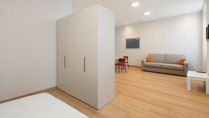 Een moderne woonkamer met een bank, een eettafel en een grote inloopkast.