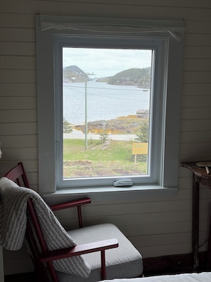 Una habitación con ventana que da a una masa de agua y un cartel que dice 'HERPING'.