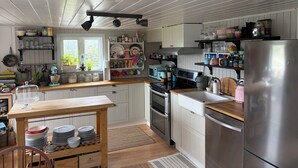 Keittiössä on puiset kaapit, ruostumattomasta teräksestä valmistettu jääkaappi sekä erilaisia keittiölaitteita.