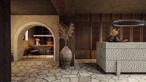 A reception area with a stone floor, a reception desk, a large vase with dried plants, and a wooden wall with horizontal slats. - Ella Elyra - Adults Only - All Inclusive (Corfu)