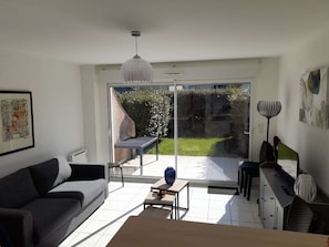 Ein modernes Wohnzimmer mit einer Couch, einem Couchtisch und einem Essbereich mit Tisch und Stühlen.