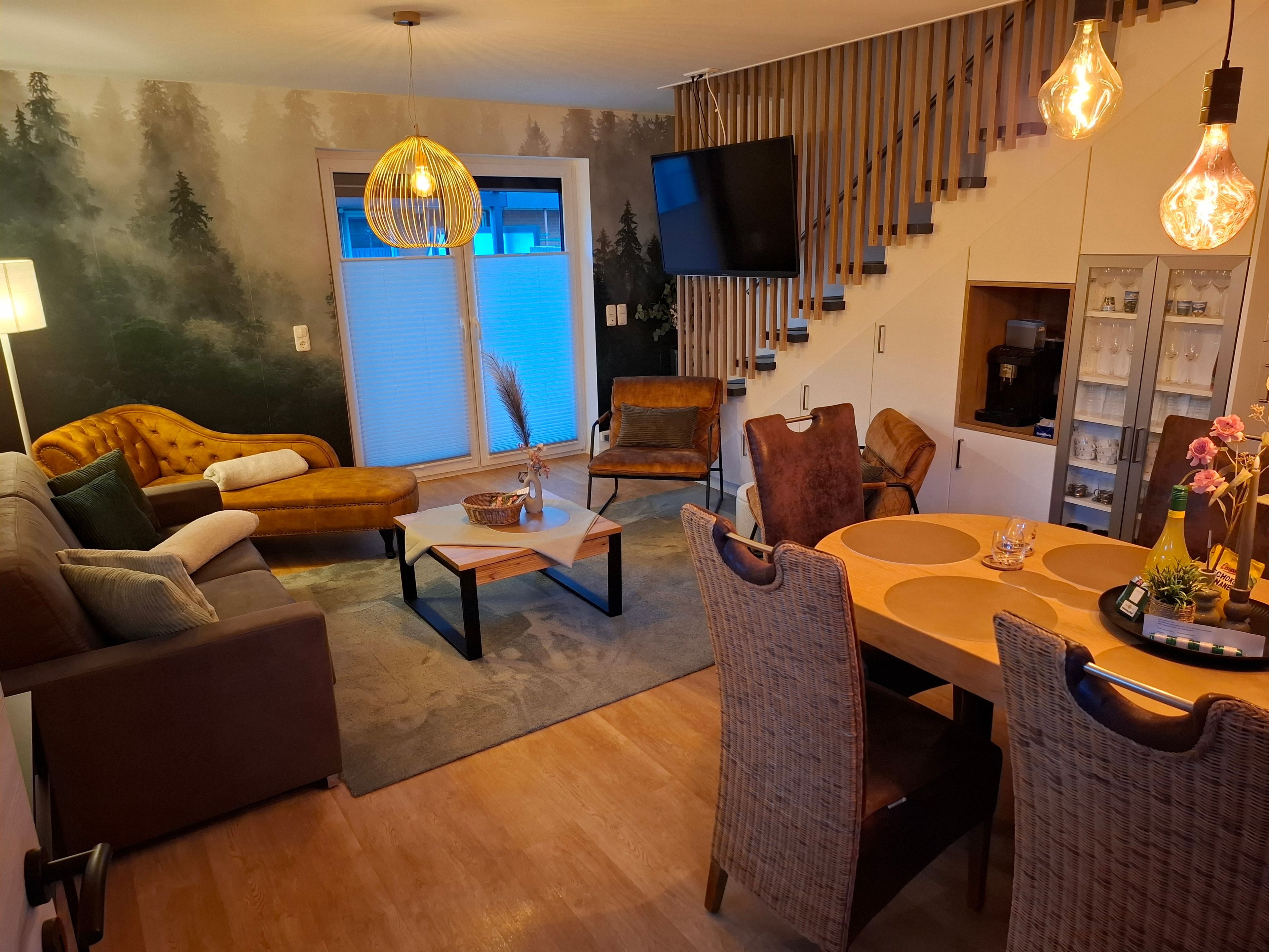 A modern living room with a sofa, chairs, a coffee table, and a dining area with a table and chairs.