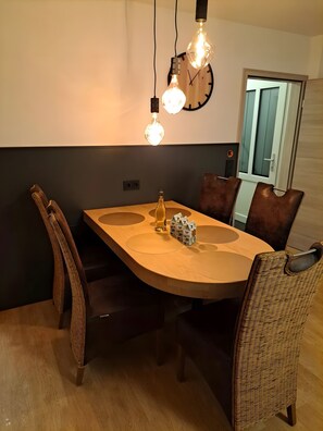 Ein Essbereich mit Holztisch, Stühlen und Pendelleuchten.
