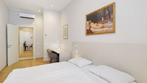 Ein Hotelzimmer mit einem großen Bett, einem Schreibtisch und einem Gemälde an der Wand.