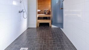 Une salle de bain moderne avec des carreaux blancs, un plafond en bois, une douche et une porte bleue.
