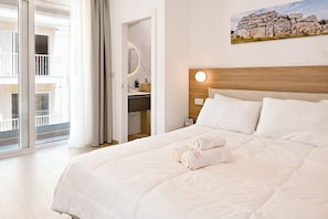 Ein Hotelzimmer mit Bett, Badezimmer mit Spiegel und Balkon mit Blick.