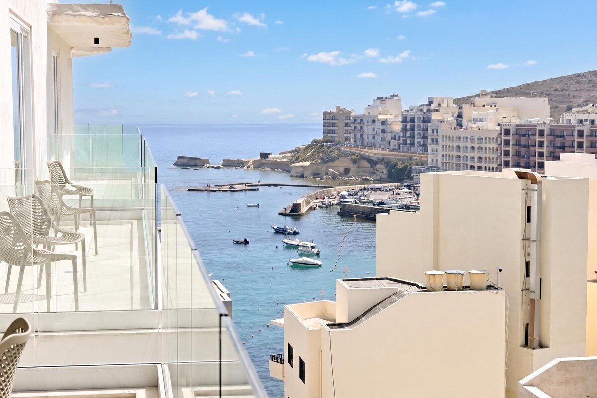 Ein Balkon mit Blick auf das Meer, Boote und Gebäude.