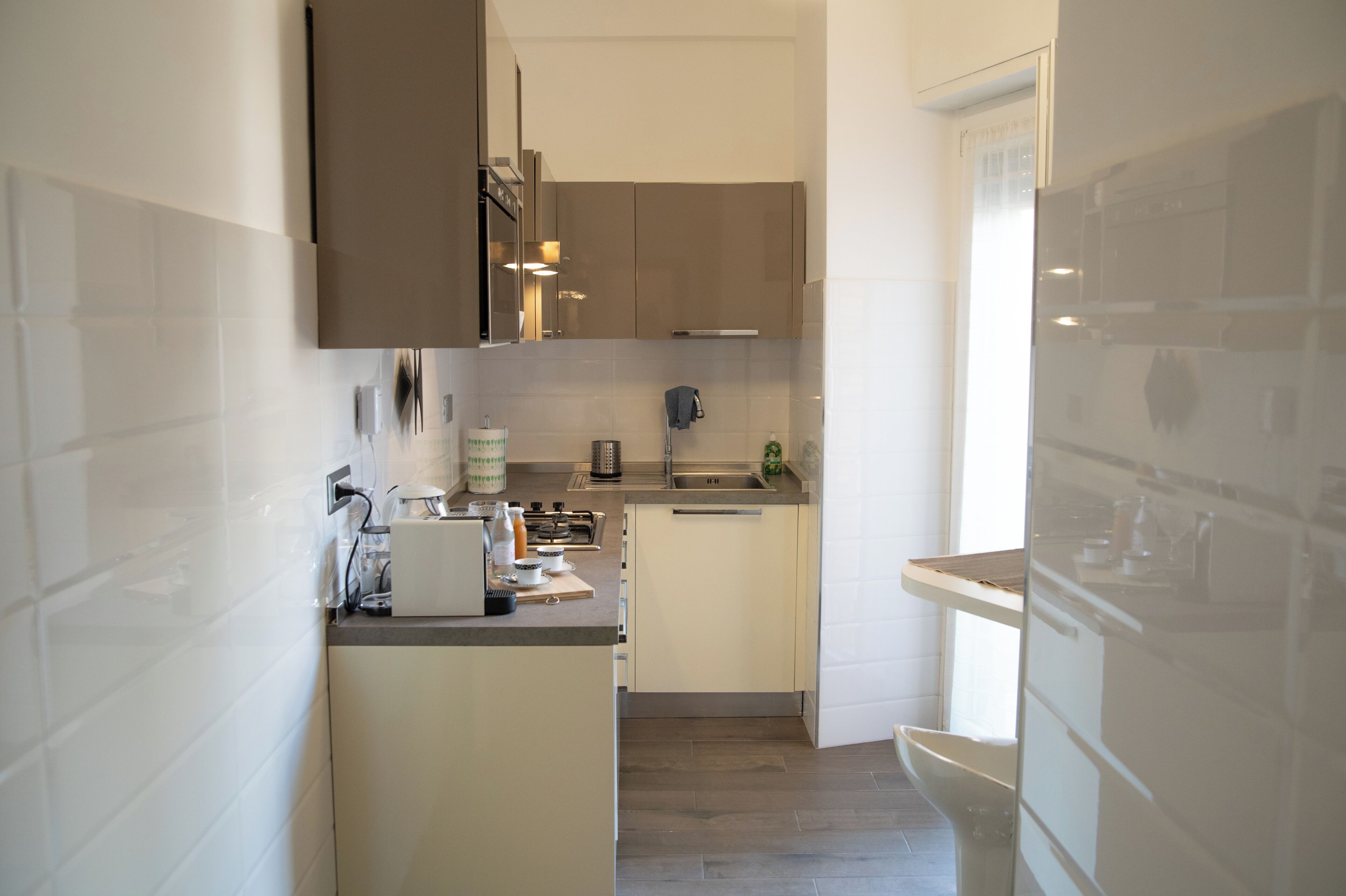 A compact kitchen with modern appliances, a built-in oven, and a sink.