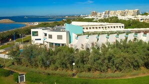 A coastal hotel with modern architecture, a pool area, and a view of the sea. - Studio Terrace 263 by the Sea (La Grande-Motte)